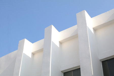 White Concrete Building Corner with blue sky. Minimal Shape Abstract Exterior Warehouse or Construction Element Conceptの写真素材