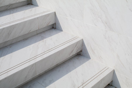 White marble stairs of a corridor with sunlight. Beautiful natural stone modern building. Minimal background. Backyard in the afternoon mood.の写真素材