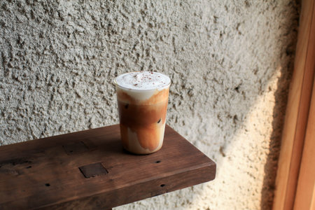 Ice cappuccino coffee. Cold summer drink. Early morning sun light. Cold summer drink on a dark...