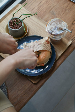 Bagel filled with smoked salmon. in blue plate on wooden table. Healthy breakfast food. Top view and...
