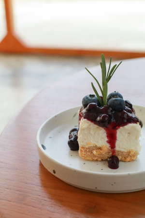 Blueberry cheesecake on white plate. Enjoy fresh baked dessert in Coffee Shop. Closeup shot of little sweet decorative cake.の写真素材