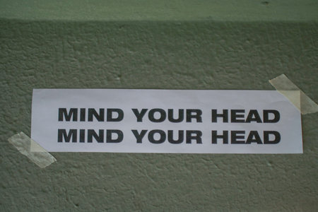 Mind Your Head sign Above Doorway or foot step. Low up ceiling caution, head lowering instruction, drop hazardの写真素材