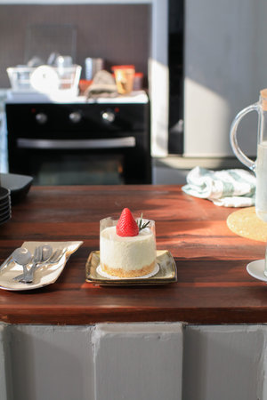 Cheesecake with fresh strawberries on wooden table with sunlight. Delicious and simple cake....