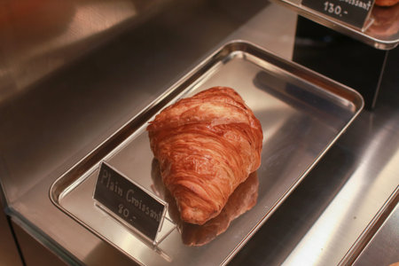 Fresh croissant crispy golden bread on silver tray. Delicious French breakfast. Warm Fresh Buttery...