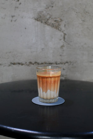 Dirty Coffee, Espresso shot mixed with cold fresh milk on black table in coffee shop cafe and restaurant. Morning breakfast.の写真素材