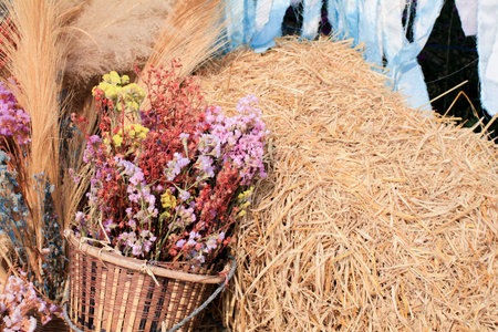 Wicker basket with colorful flowers on brown straw. Beautiful Bouquet in a summer. Floral...