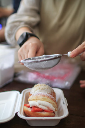 Sweet donuts strawberry with powder sugar  and cream cheese on wooden cutting board in cafe. Prepare...