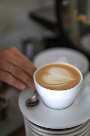 Hot Latte espresso coffee with heart shape latte art in white ceramic cup. Cafe Bar or Coffee Houseの写真素材