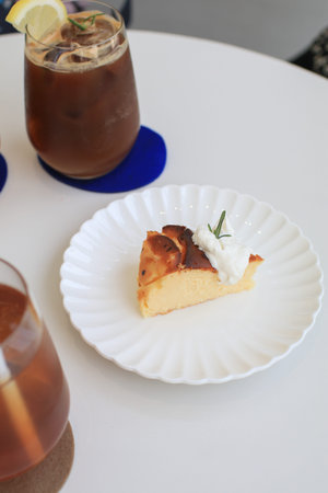 Basques Cheesecake with cream on white plate. A piece of cake on table in cafe. dessert. Fresh baked...