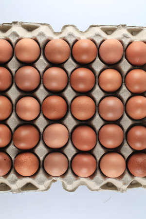 Raw chicken eggs in egg carton on white background. Natural healthy food and organic farming...
