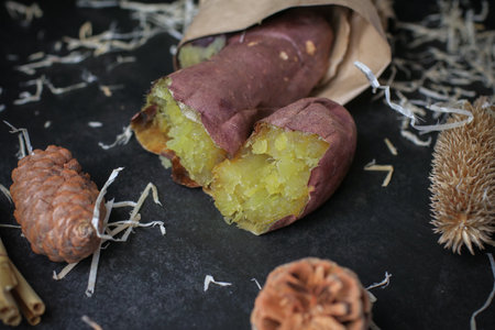 Japanese roasted sweet potato on dark background. Organic healthy vegetable. Fresh natural root.の写真素材
