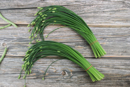 Garlic chives or Allium tuberosum on wooden table background. Fresh healthy organic green vegetable.の写真素材