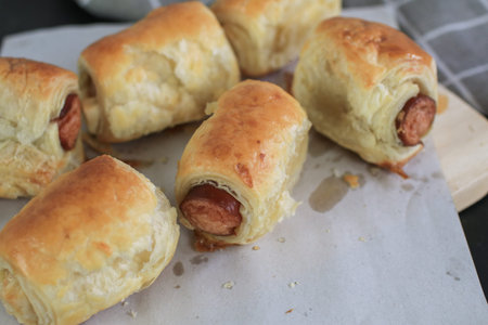 Sausage rolls on wooden table. Puff pastry eat with coffee or tea. Traditional British food concept. Food photographyの写真素材