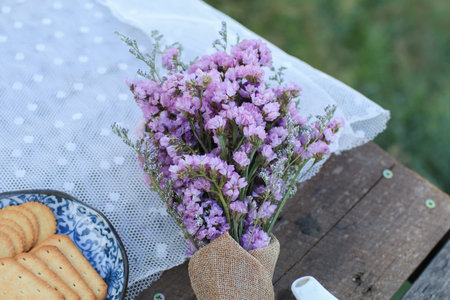 Violet flower with biscuit on wooden table landscape mountain view on background. Enjoy morning ...