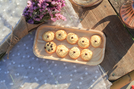 Butter cookie on wooden tray eating coffee under morning sunlight and purple flower on table....