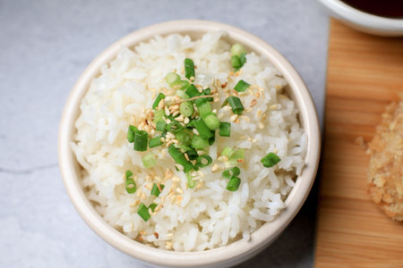 Steamed rice with black sesame seeds and spring onion in ceramic bowl on table. Japanese and Asia eat with foodの写真素材