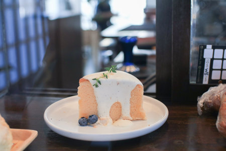 Lemon cheese cake with whipping cream on top on white plate. Tropical Dessert in coffee shop.の写真素材