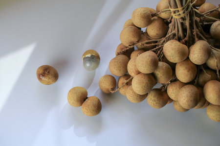 Fresh natural Longan fruits under sunlight on white table. Dimocarpus longan. Tropical fruit.の写真素材