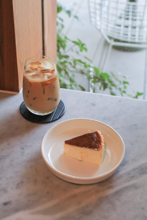 Basque Cheesecake on white plate. Fresh baked by homemade recipe. Delicious dessert in coffee shop.