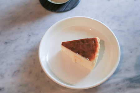 Basque Cheesecake on white plate. Fresh baked by homemade recipe. Delicious dessert in coffee shop.の写真素材