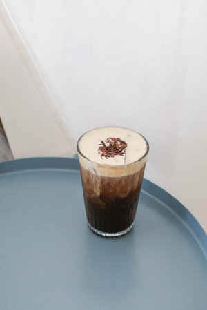 Irish coffee with cream on table in cafe. Tasty delicious festive coffee drink in morning breakfast.