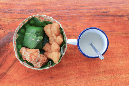 Pa Tong Go and Sticky Rice with Egg Custard in banana left eat with soy milk on wooden table. Thai style breakfast.の写真素材