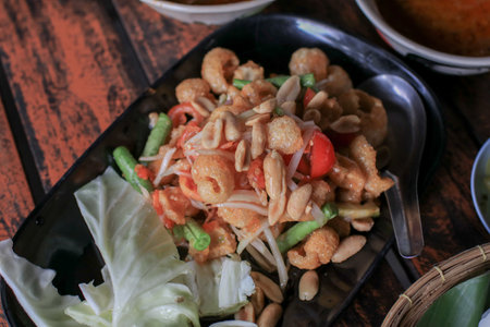 Crispy Fish Maw in Spicy Salad, "Yum Sam Grob" in black plate. Thai food. Restaurant.の写真素材