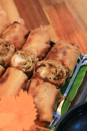 Deep fried shrimp spring rolls filling with cabbage, carrot and glass noodles eating with sweet dipping sauceの写真素材