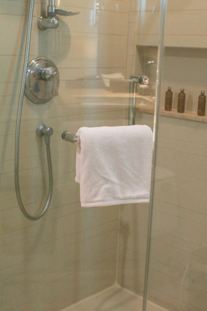 Fresh white towel arrangement metal shelves or hanging in modern minimal bathroom interior. Daily body care, spa and wellness.の写真素材
