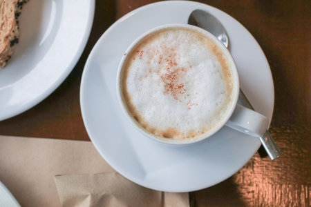 Hot coffee latte cappuccino with milk foam on wooden table for morning breakfast. Refreshing drink.の写真素材