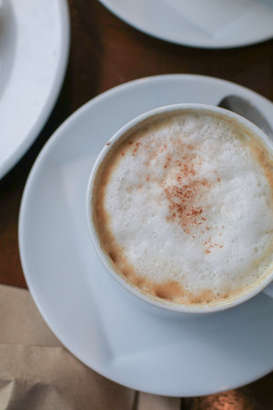 Hot coffee latte cappuccino with milk foam on wooden table for morning breakfast. Refreshing drink.の写真素材