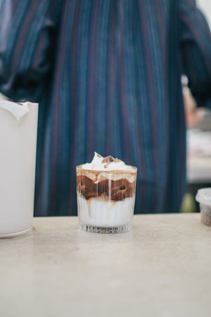 Ice coffee latte with cream on top in cafe. Cold summer drink. Breakfast beverage morning concept.の写真素材