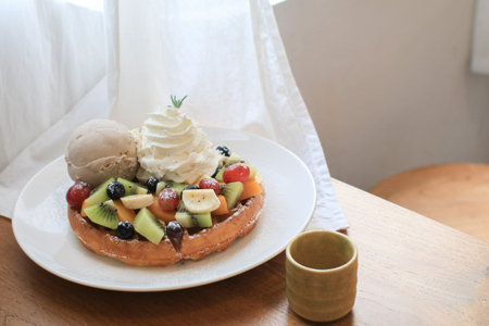 Waffles with strawberry, kiwi, banana and whipped cream in white plate on sheer curtain. Morning...