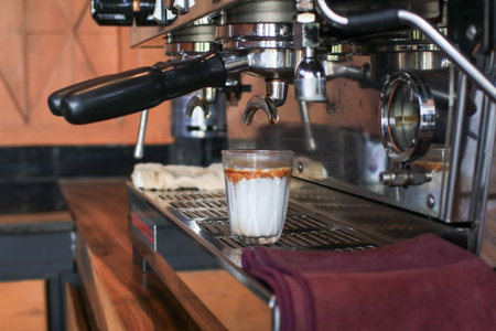 Coffee machine making espresso shot on fresh milk create gradient layer called dirty coffee.の写真素材