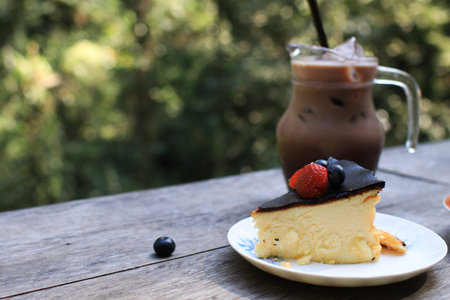 Basque cheesecake with blueberry and strawberry on top. Homemade pastry on wooden table.の写真素材