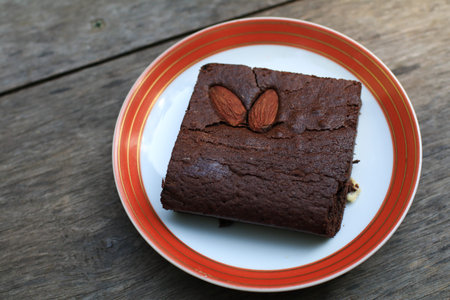 Delicious chocolate brownies with almond on wooden table. Homemade sweet dessert baking.の写真素材