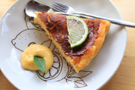 Homemade Basque cheesecake with slice lime on top and lemon curd cream. Dessert bakery.の写真素材