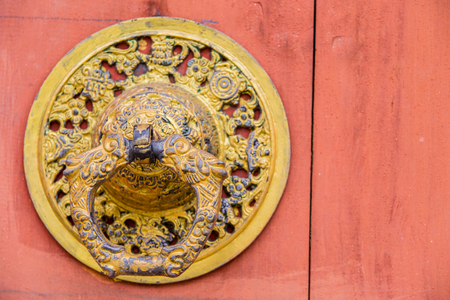 old dragon door knocker on red door.の写真素材