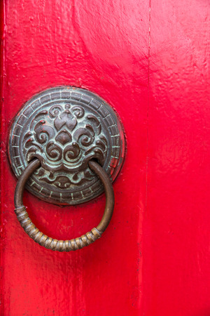 holder for door knocker and copper nails on a red door.の写真素材