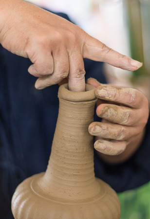 close up of the hands of a potter creating a jug on the circle.の写真素材