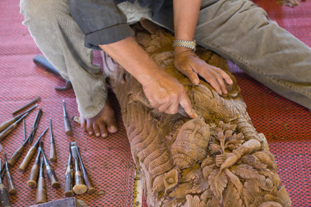A craftsman working wood the oldfashioned way, hammer and chisel used to carve shape into a piece of wood.の写真素材