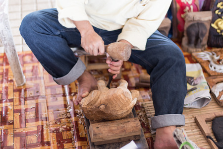 A craftsman working wood the oldfashioned way, hammer and chisel used to carve shape into a piece of wood.の写真素材
