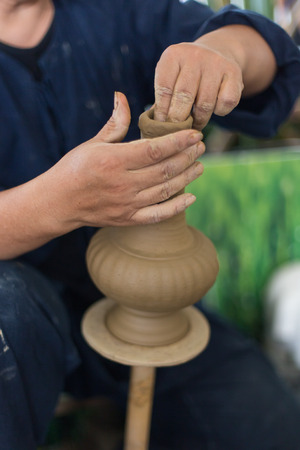 close up of the hands of a potter creating a jug on the circle.の写真素材