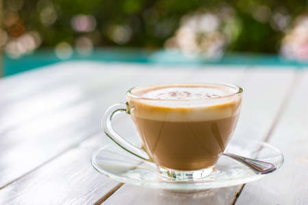 A cup of coffee in a white cup on wooden background.の写真素材