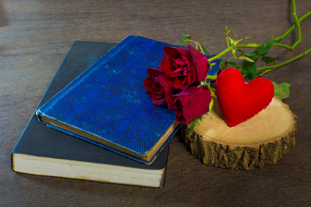 Roses on old books and glasses, small heart on wood timberの写真素材
