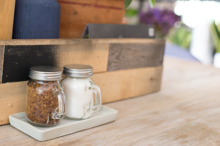 Brown sugar in the bottles on wooden table.の写真素材