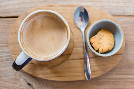 Drinked hot Latte Coffee heart art and cookie on the wooden table.