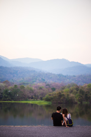 couple  at sunset sitting in lakeの写真素材