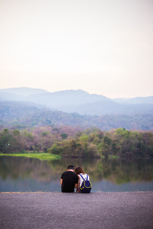 couple  at sunset sitting in lakeの写真素材