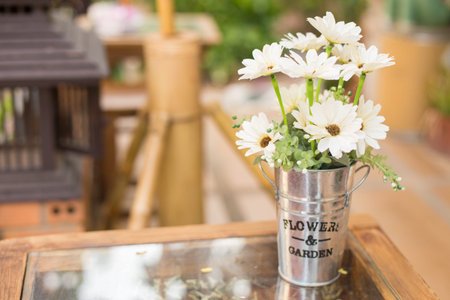 bouquet daisies in zinc cans on table in coffee shop.の写真素材